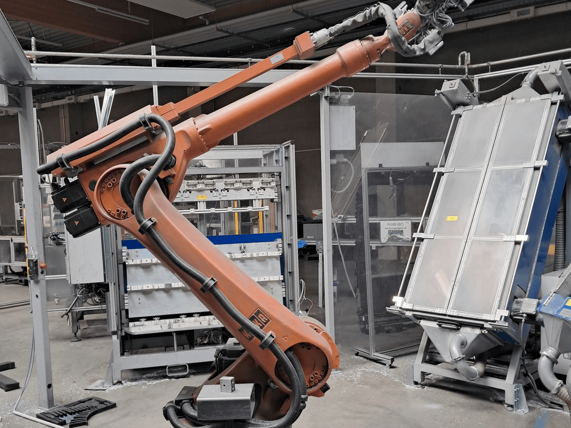 Robotické rameno KUKA KR 30L16-2 v továrním prostředí, boční pohled s viditelnými kabely a mechanickými součástmi.