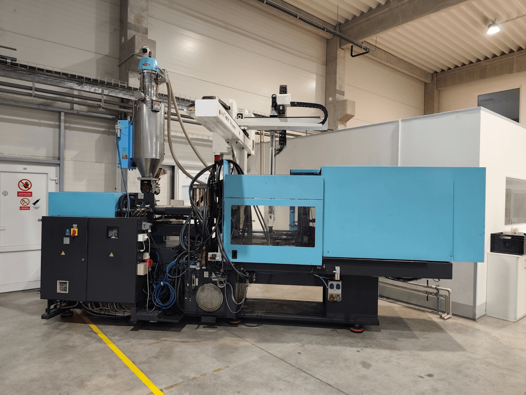 Pohled zepředu na hydraulický vstřikovací stroj DEMAG Ergotech Extra 160-430 s viditelným ovládacím panelem a násypkou.
