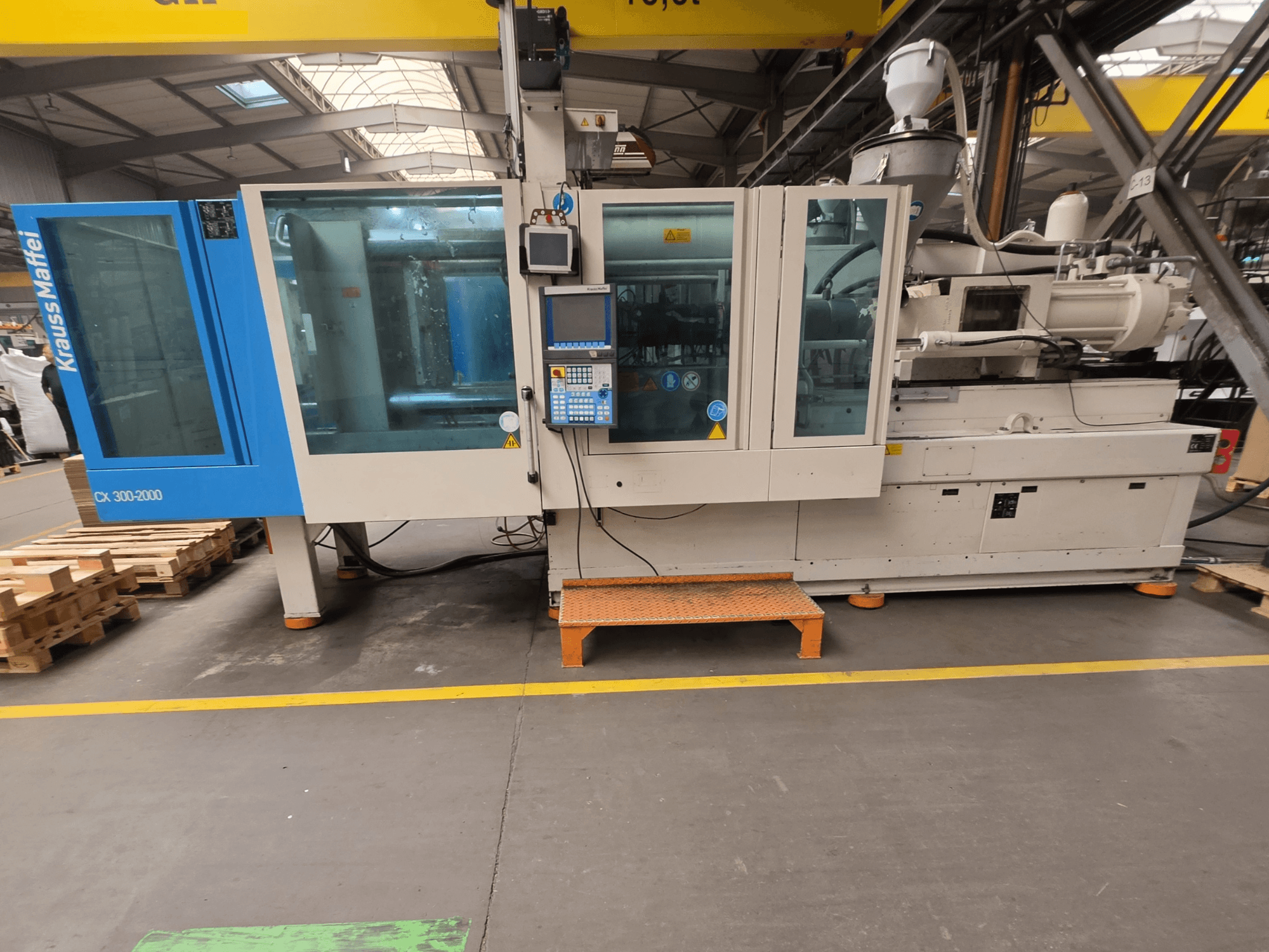 Hydraulický vstřikovací stroj Krauss Maffei 300-2000 CX, boční pohled na ovládací panel a velká okna.