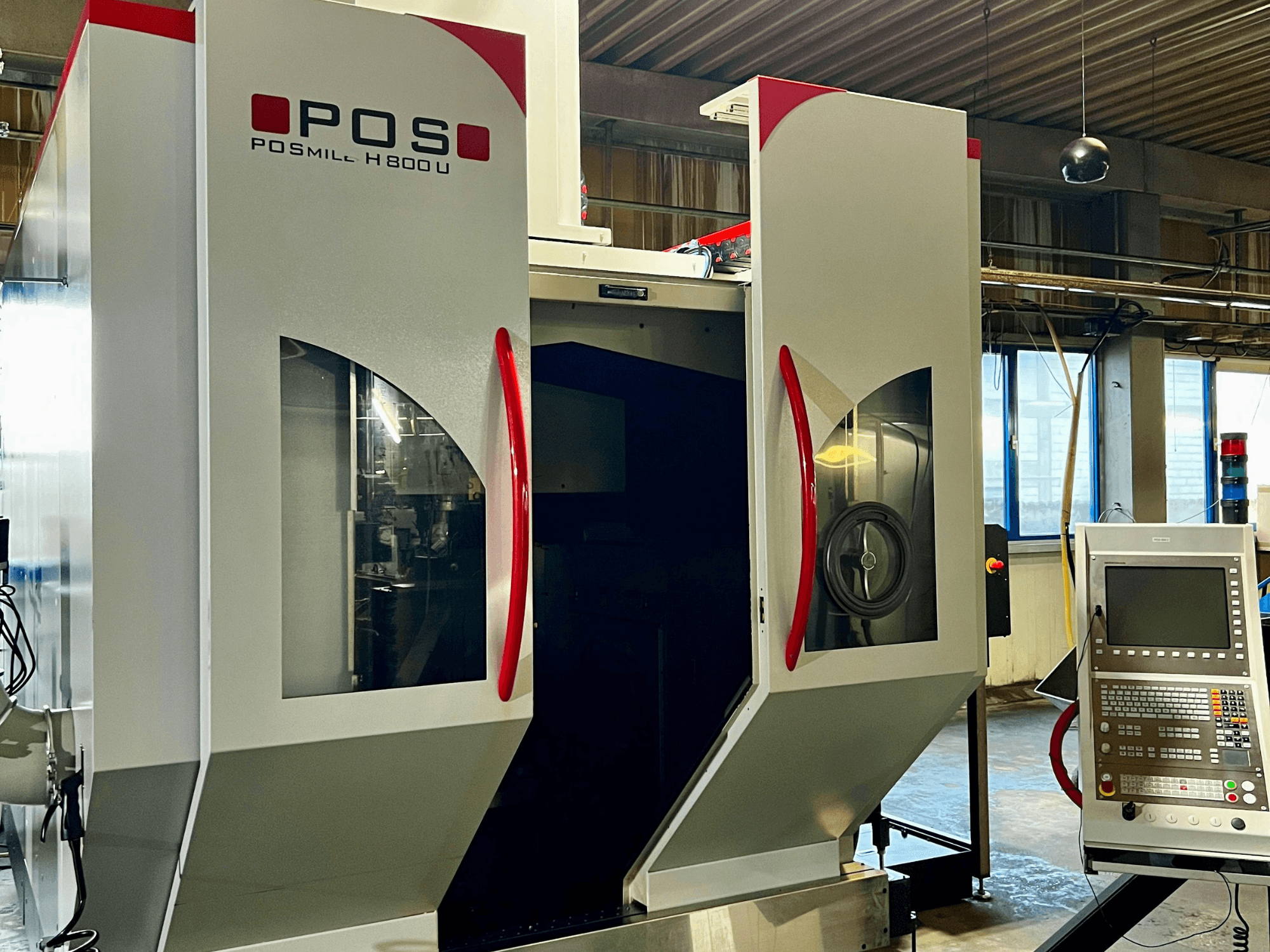 Univerzální obráběcí centrum POSmill H800U při pohledu zepředu s ovládacím panelem a otevřenými dvířky, které odhalují vnitřní součásti.