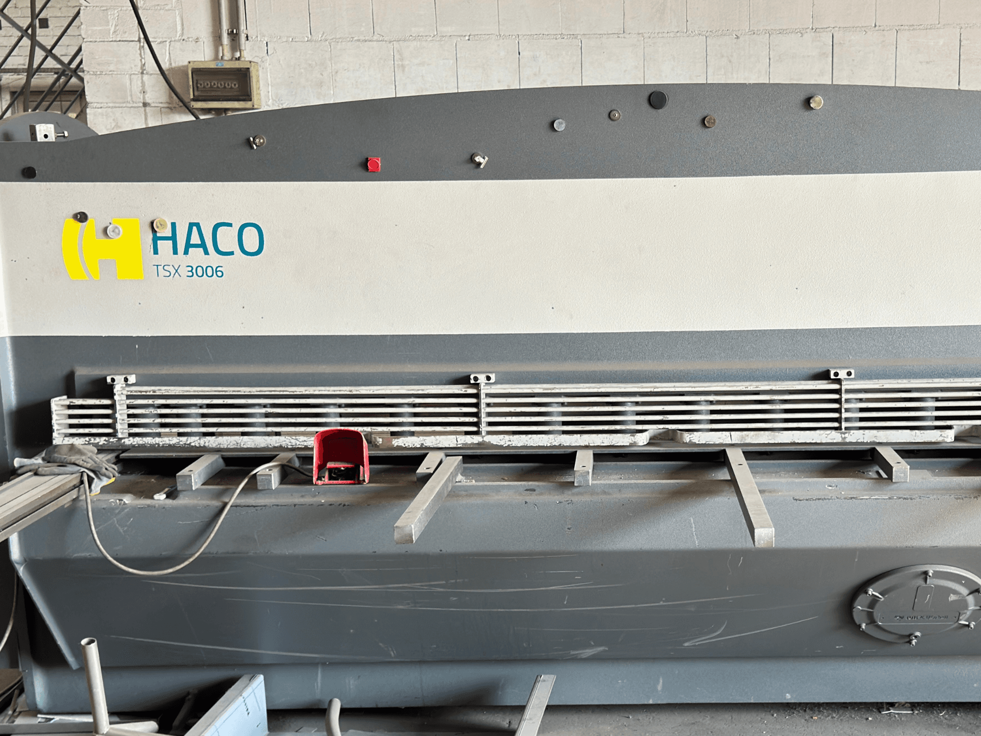 Hydraulické nůžky HACO TSX3006 MOT, pohled zepředu, s kovovými řezacími noži a ovládacím panelem, zobrazující provozní detaily.