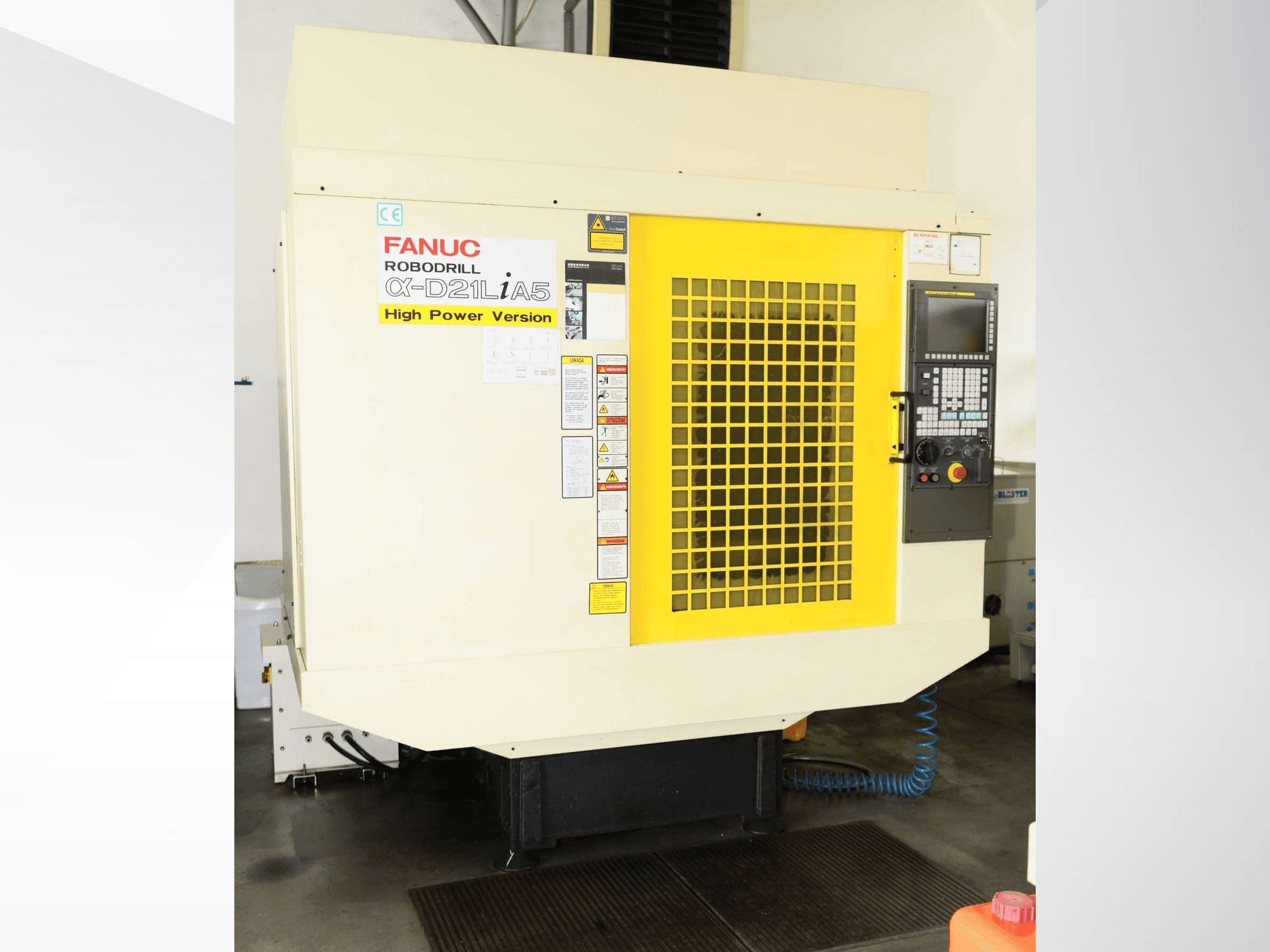 Vertikální obráběcí centrum FANUC ROBODRILL α-D21LiA5, pohled zepředu se žlutou bezpečnostní mřížkou a detaily ovládacího panelu.