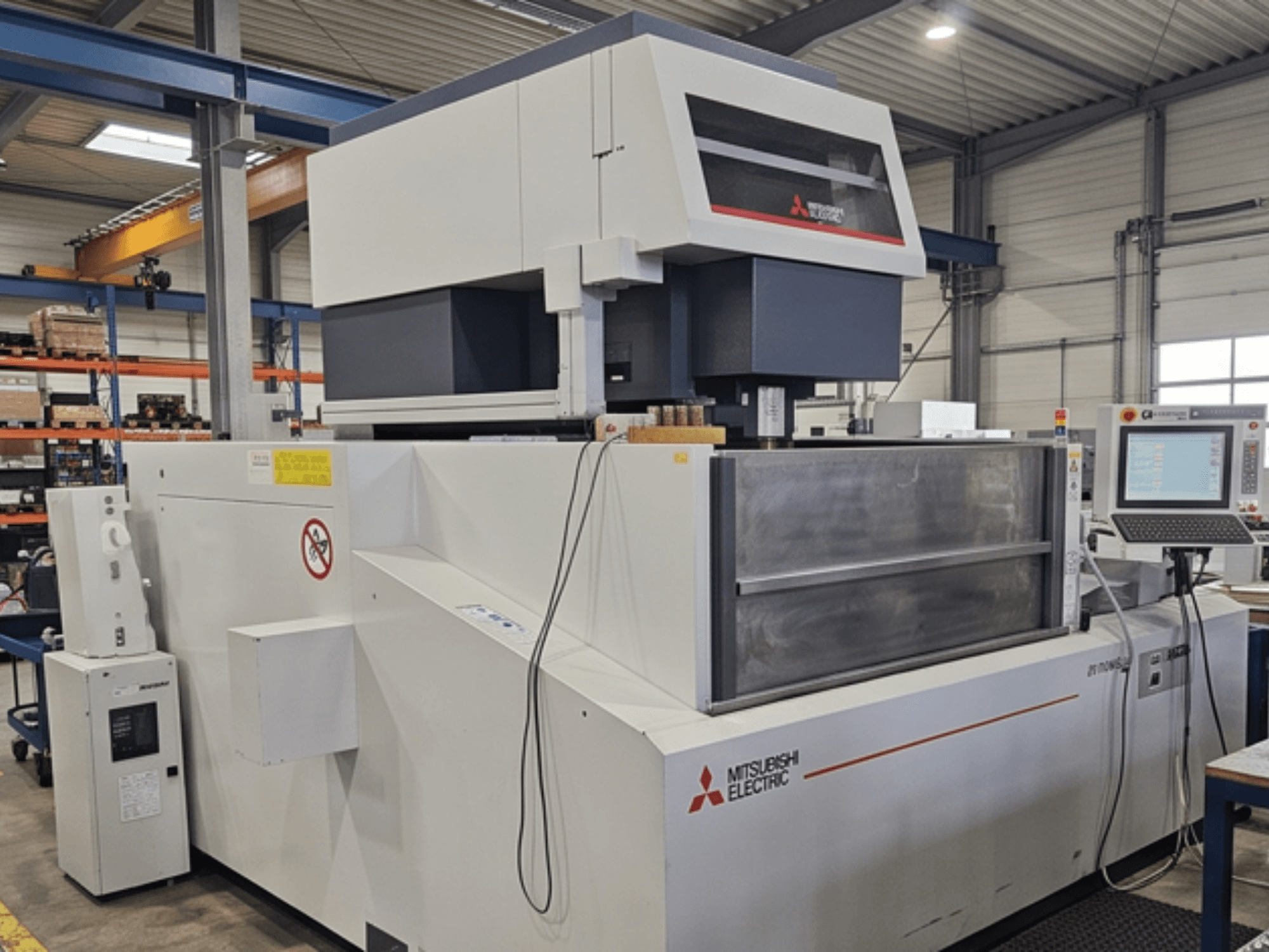 Elektroerozivní stroj Mitsubishi MV-4800, pohled zepředu, znázorňující ovládací panel a pracovní prostor v továrním prostředí.