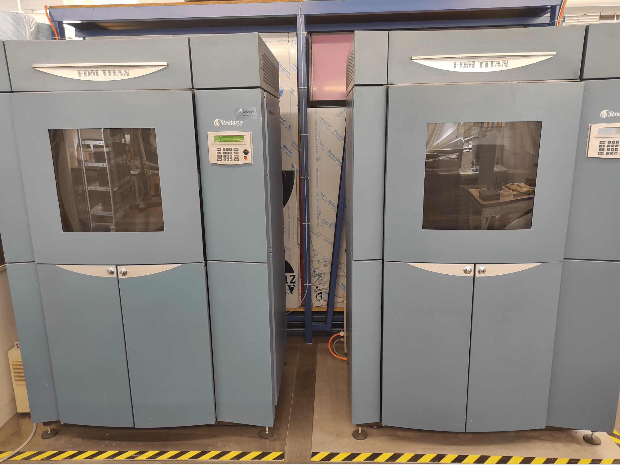Pohled zepředu na plastovou 3D tiskárnu Stratasys FDM TitanTI T0031; je vybavena ovládacím panelem a průhledným okénkem.