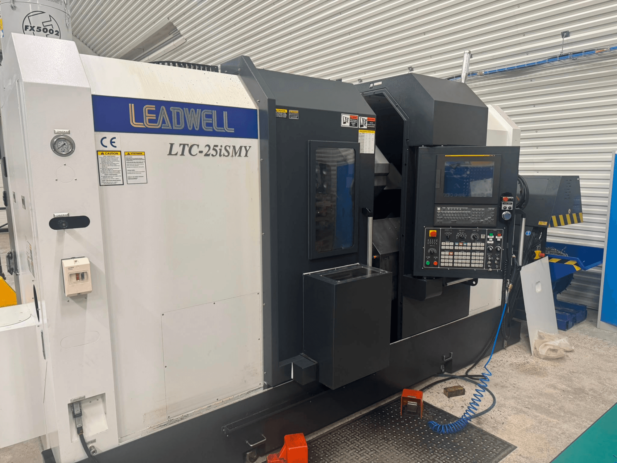 Horizontální soustruh Leadwell LTC-25iSMY z čelního pohledu, na kterém je vidět ovládací panel a uživatelská rozhraní.
