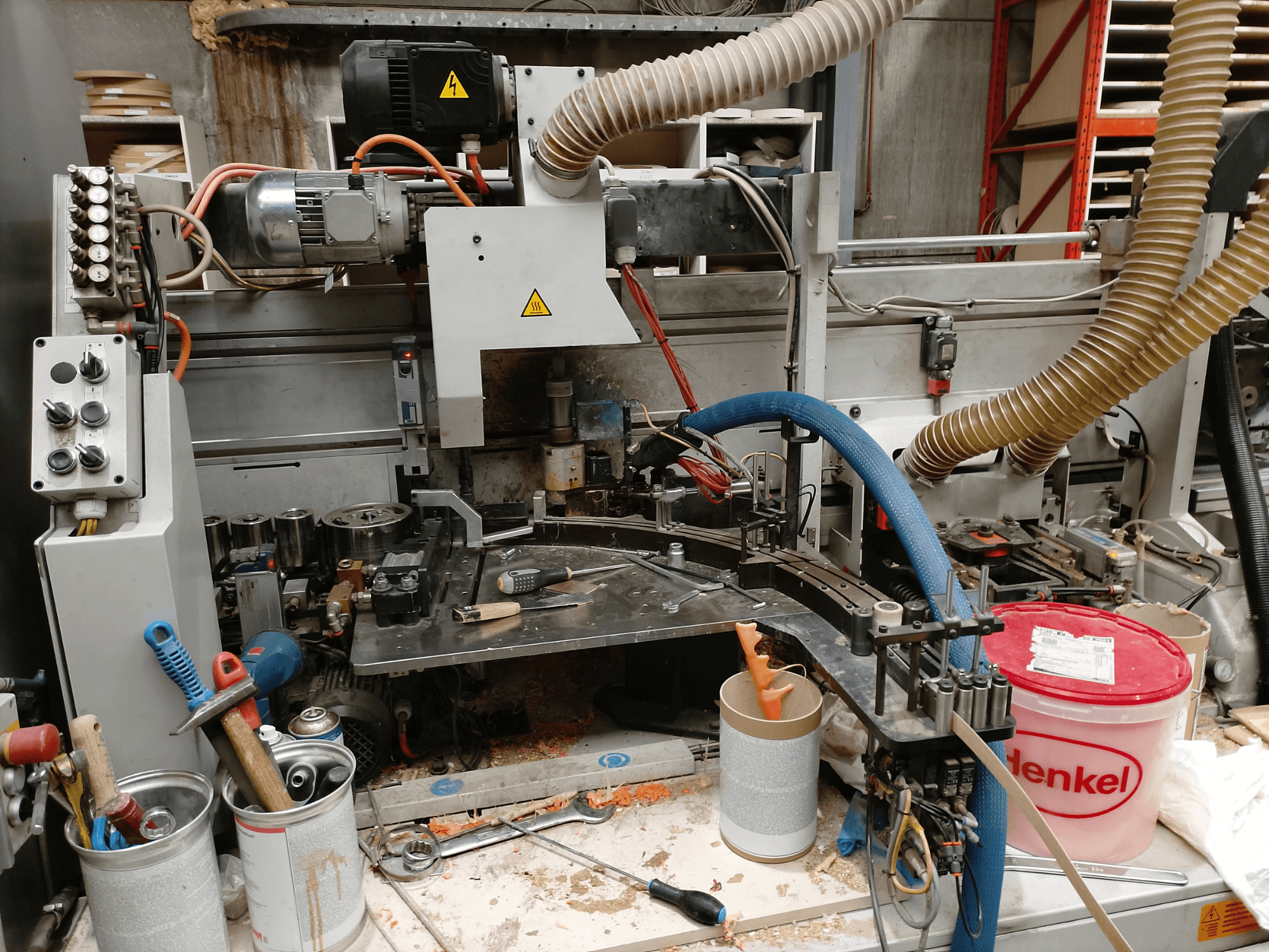 Olepovačka hran BIESSE Edge Stram B1 v čelním pohledu, strojní zařízení, hadice a pracovní nástroje mezi hoblinami.