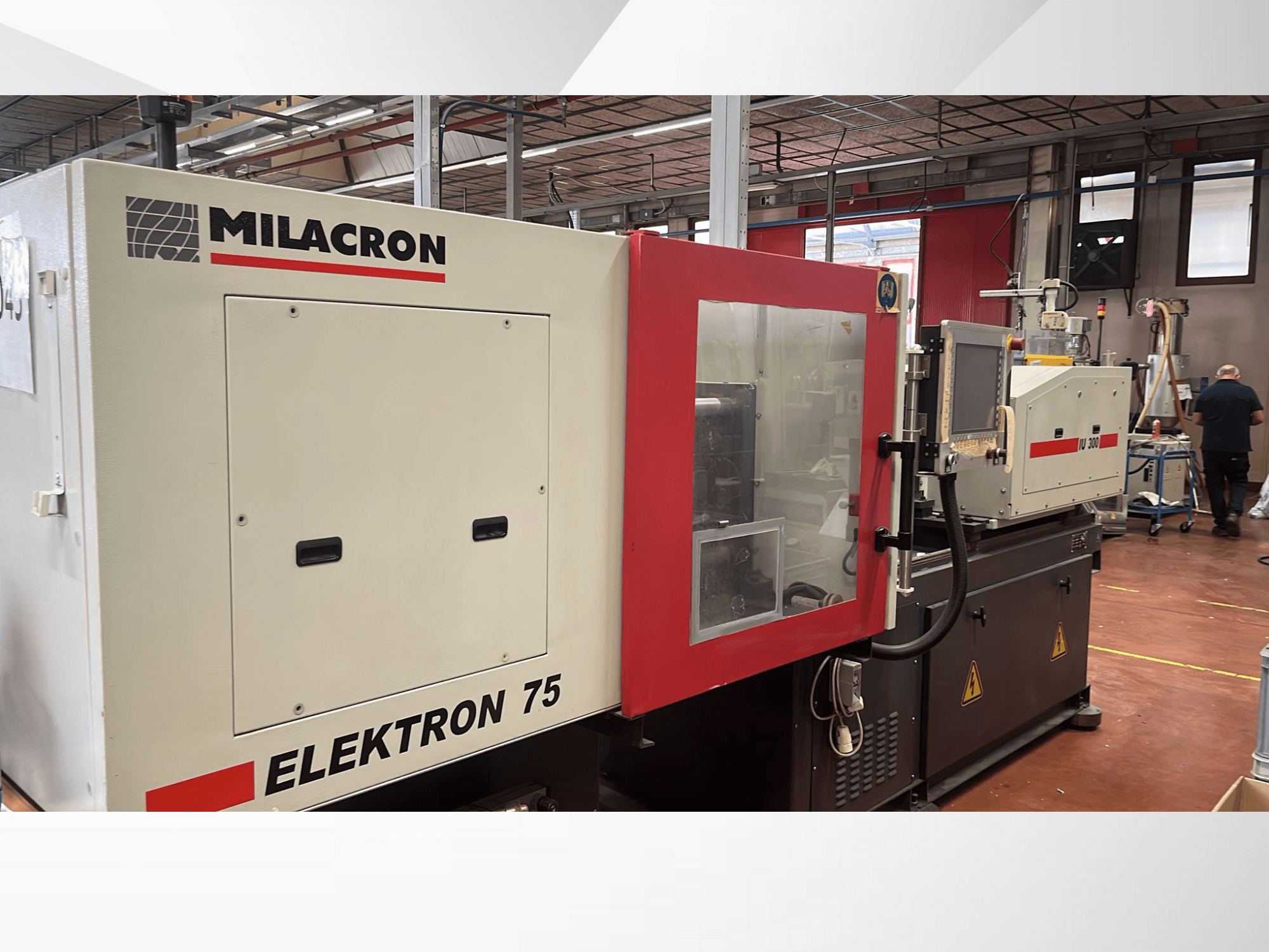 Vstřikovací stroj Milacron Elektron 75 v dílně, boční pohled na ovládací panel a mechanické části.