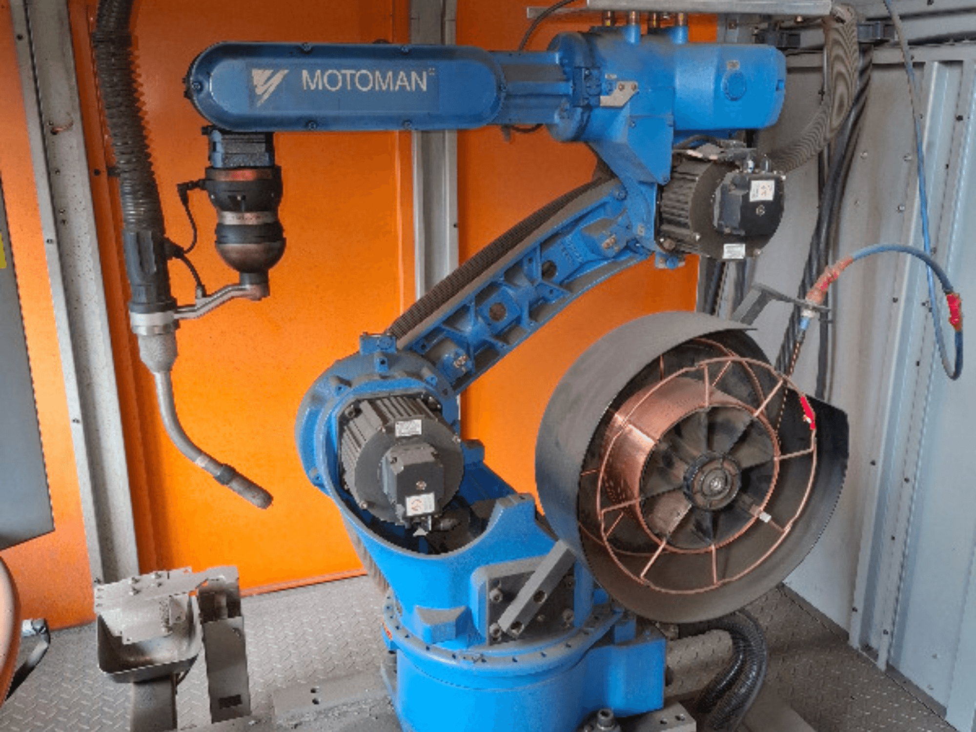 Robotické rameno MOTOMAN v modré barvě, boční pohled, s připojeným ventilátorem a nástroji, zobrazení mechanických detailů a připojení.