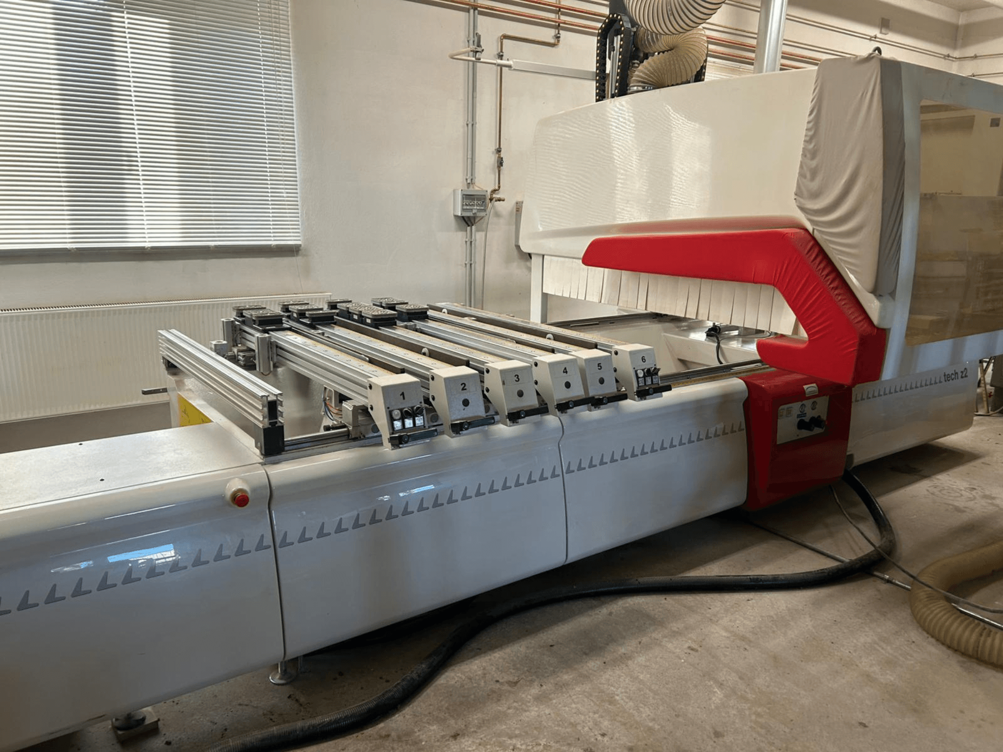 Vyvrtávačka dřeva SCM TECH Z2-27-C, boční pohled, zobrazující ovládací panel a kolejnice, s červenými a bílými designovými prvky.