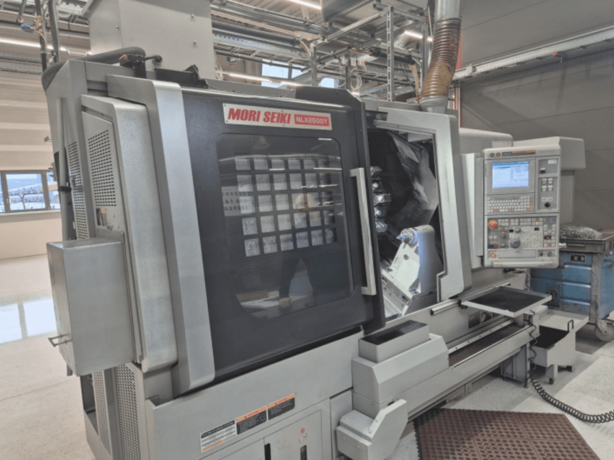 CNC soustruh MORI SEIKI NL2500Y v továrním nastavení, pohled zepředu na ovládací panel a obrobkovou komoru.