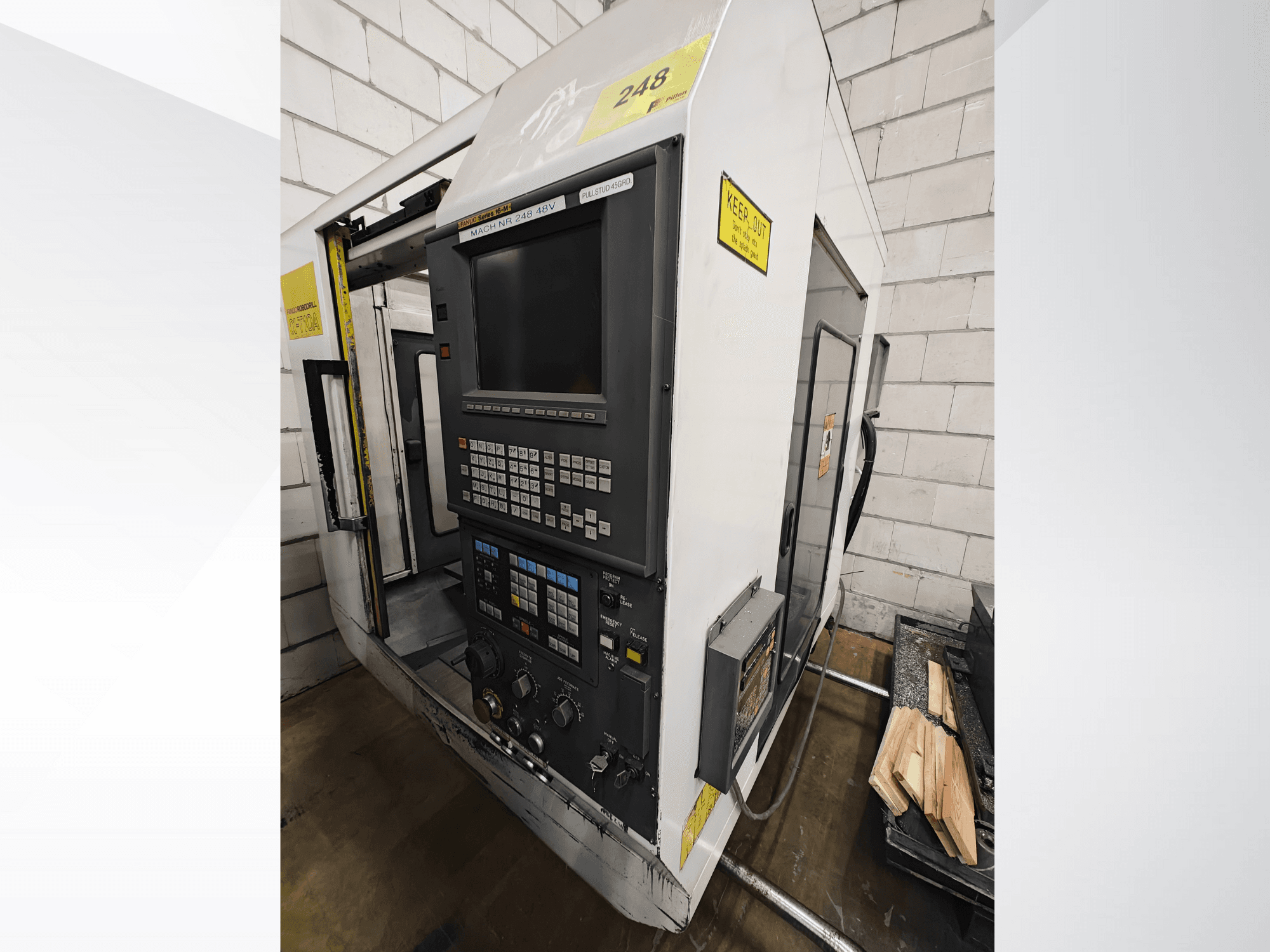 Model CNC stroje č. 248, pohled zepředu, s ovládacím panelem s tlačítky a displejem, s dřevěnými díly na polici vedle.